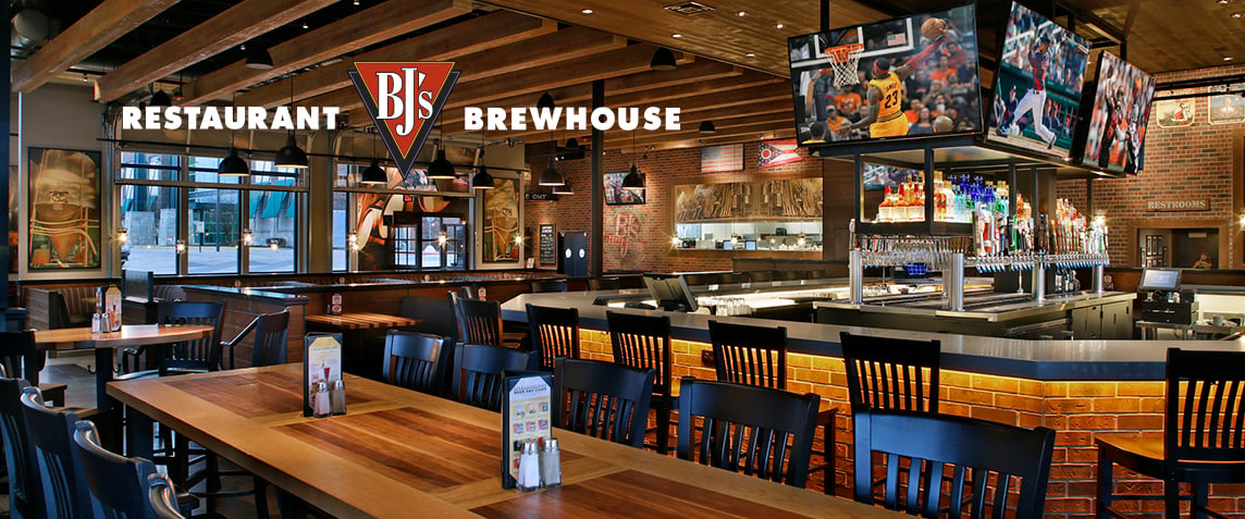 Innenansicht eines BJs Brewhouse und Restaurant mit einer großen Bar und Sportübertragungen auf Fernsehbildschirmen