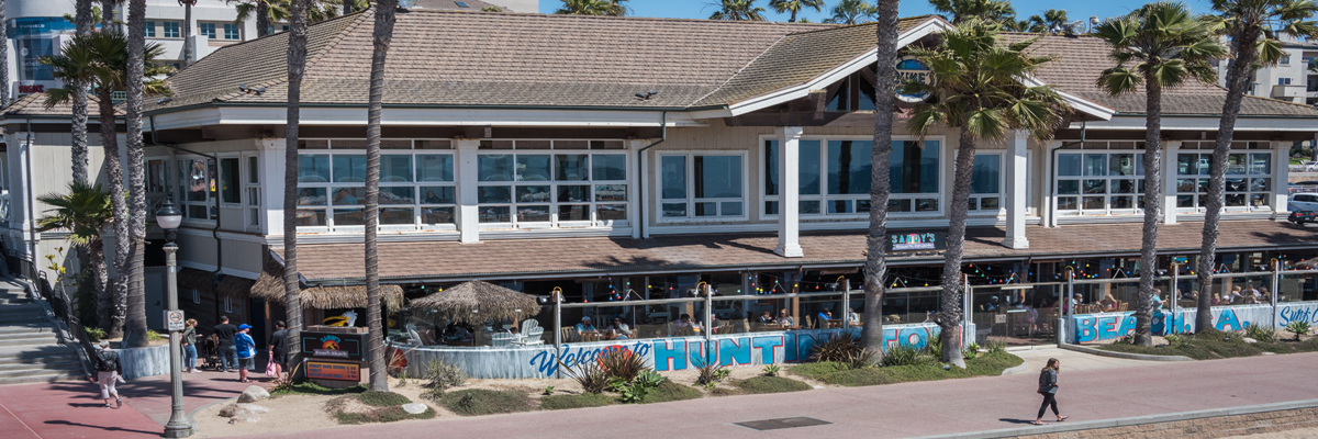Frontansicht eines Strandrestaurants an einem frohen Tag, umgeben von Handflächen