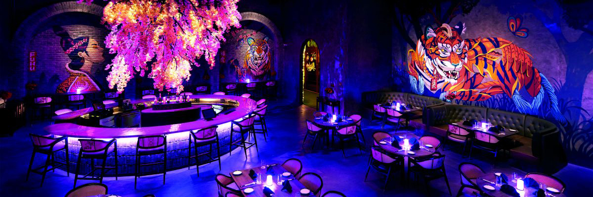 Bild, das einen Club mit Restaurantbereich zeigt, der mit violetten Lichteffekten ausgestattet ist