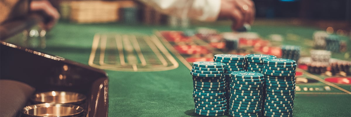 Nahaufnahme eines großen Stapels grüner Casino-Chips auf einem Roulette-Tisch