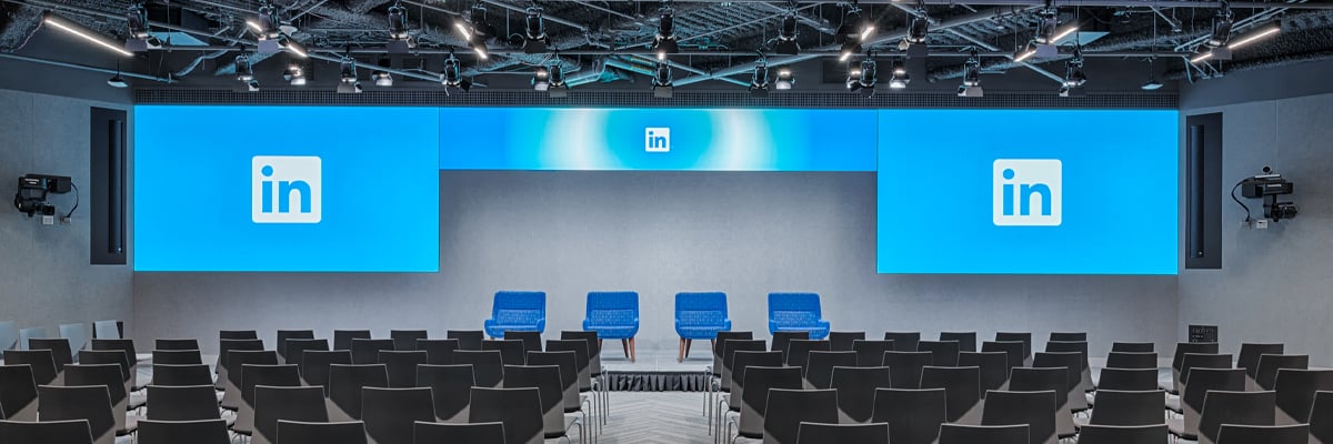 Einer der großen Besprechungsräume von LinkedIn an einem der Standorte des Unternehmens, mit Reihen von Zeichen und großen Bildschirmen, auf denen das Logo der LinkedIn Nutzer zu sehen ist